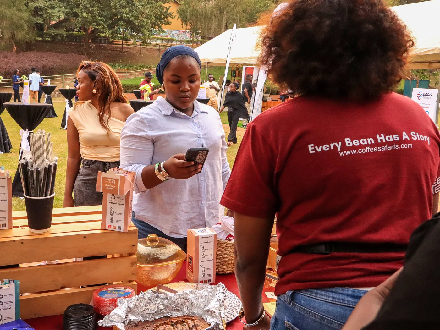 A Coffee Safaris team member's 'Every Bean Has A Story' branded t-shirt at a community coffee activation